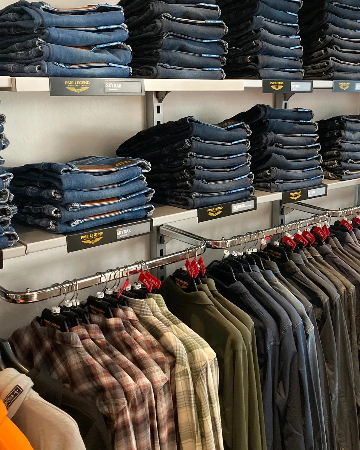 Jeans und Hemden in Regalen im Store von Gerrys House of Style